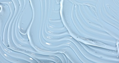 Photo of Sample of cosmetic product on light blue background, closeup