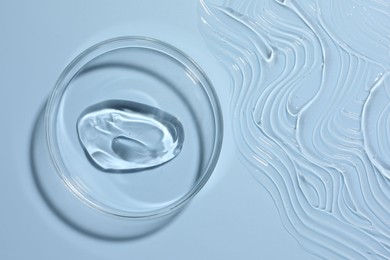 Photo of Cosmetic product in Petri dish on light blue background, top view