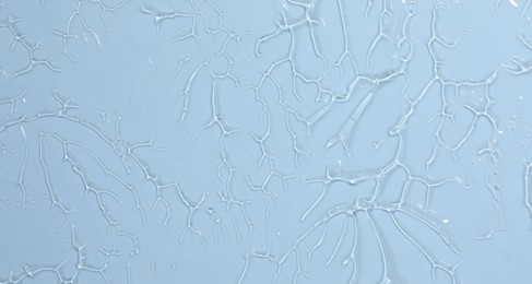 Photo of Sample of cosmetic product on light blue background, closeup