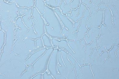 Photo of Sample of cosmetic product on light blue background, closeup
