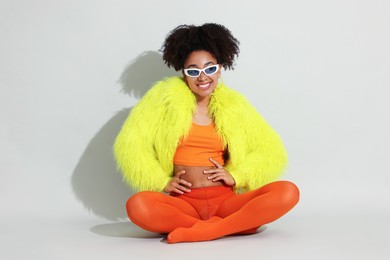 Photo of Fashionable portrait of beautiful Brazilian woman in stylish outfit on white background