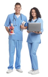 Photo of Medical students with laptop and human body model on white background