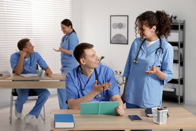 Photo of Medical students in uniforms studying together at university