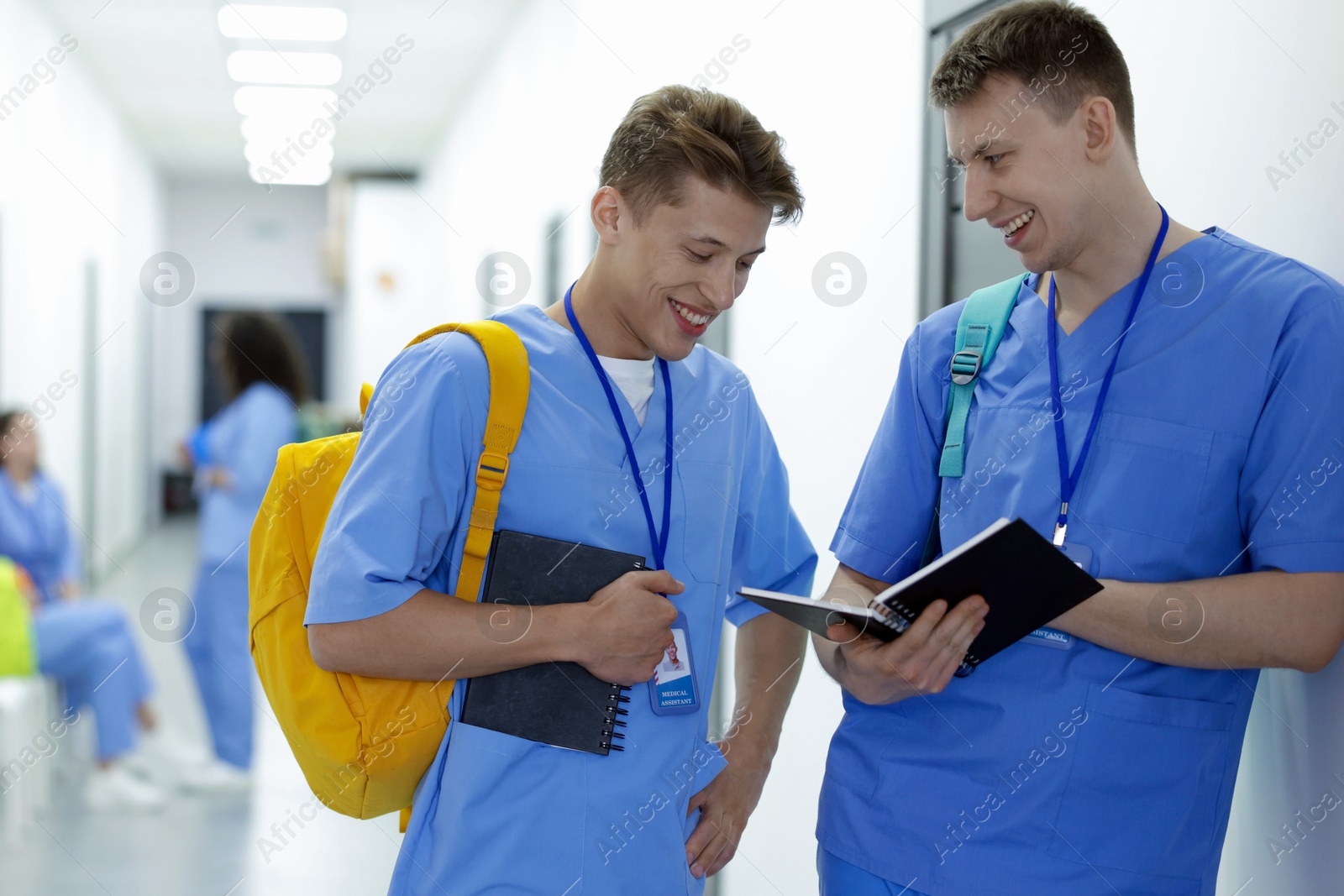 Photo of Medical student in uniforms with backpacks and notebooks at university, selective focus