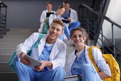 Photo of Group of medical students in uniforms on stairs indoors, low angle view