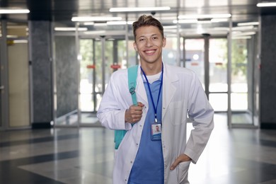 Photo of Medical student in uniform with backpack indoors