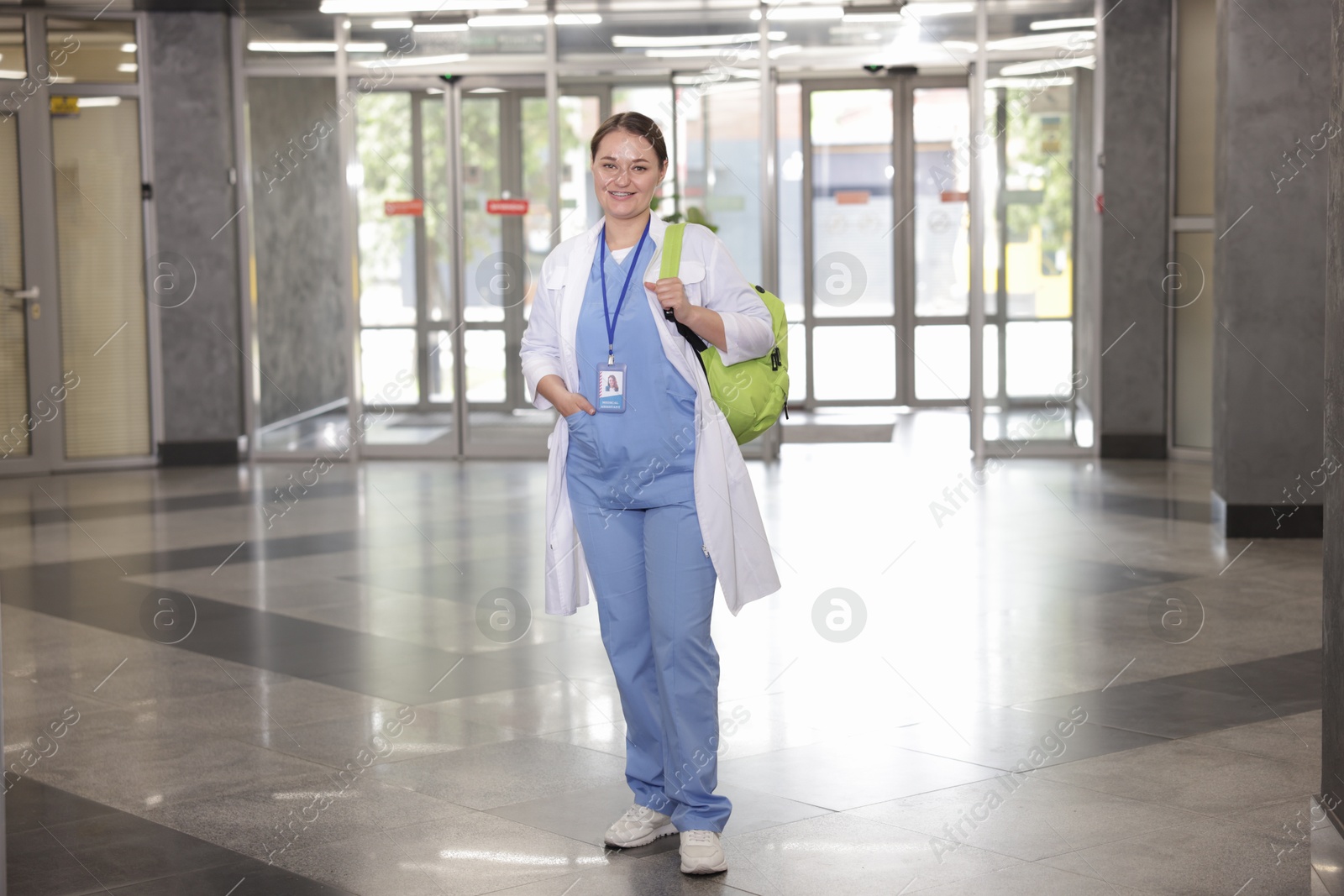 Medical student in uniform with backpack indoors Photo of Medical student in uniform with backpack indoors