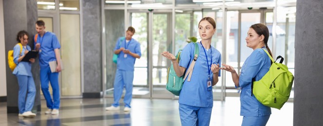 Photo of Medical students in uniforms indoors, selective focus