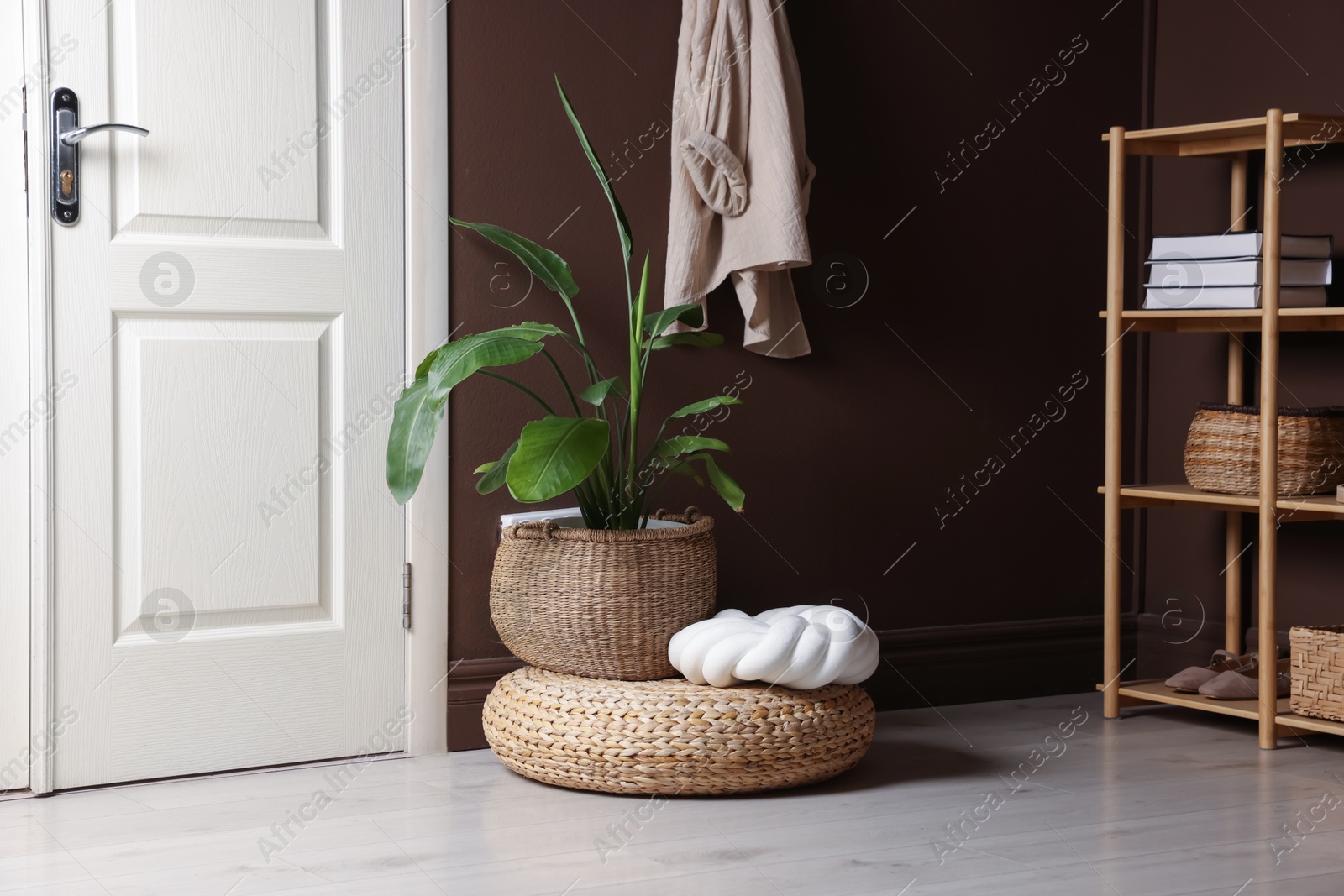 Stylish wicker pouf with houseplant and cushion at home Photo of Stylish wicker pouf with houseplant and cushion at home