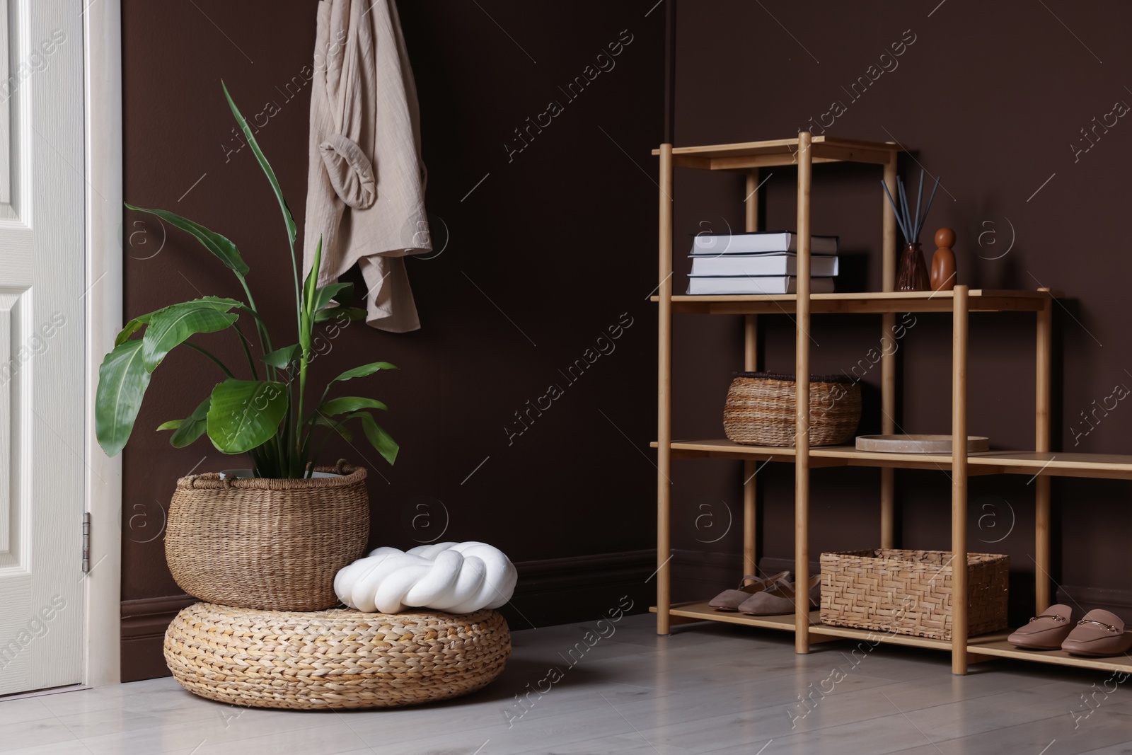 Stylish wicker pouf with houseplant and cushion at home Photo of Stylish wicker pouf with houseplant and cushion at home