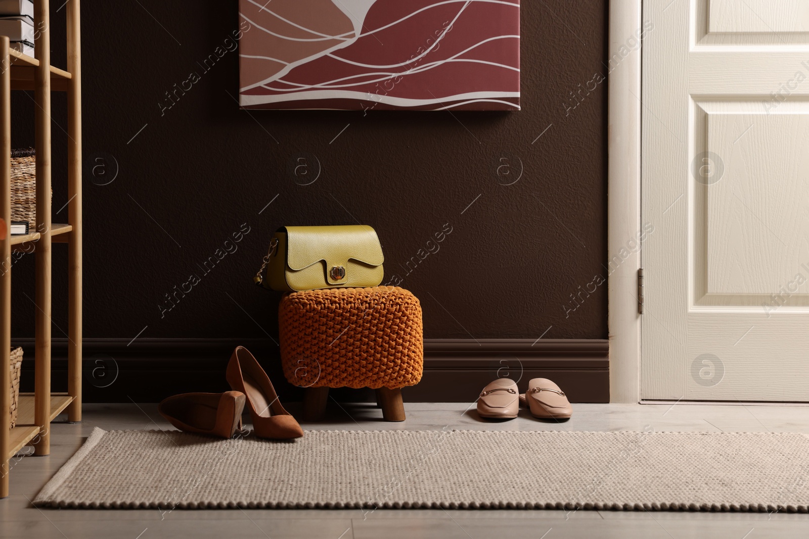 Stylish pouf with bag and shoes at home Photo of Stylish pouf with bag and shoes at home
