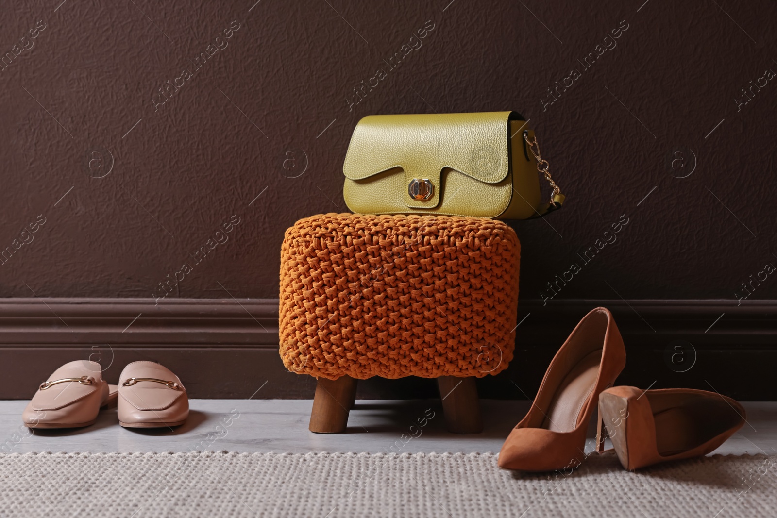 Stylish pouf with bag and shoes at home Photo of Stylish pouf with bag and shoes at home