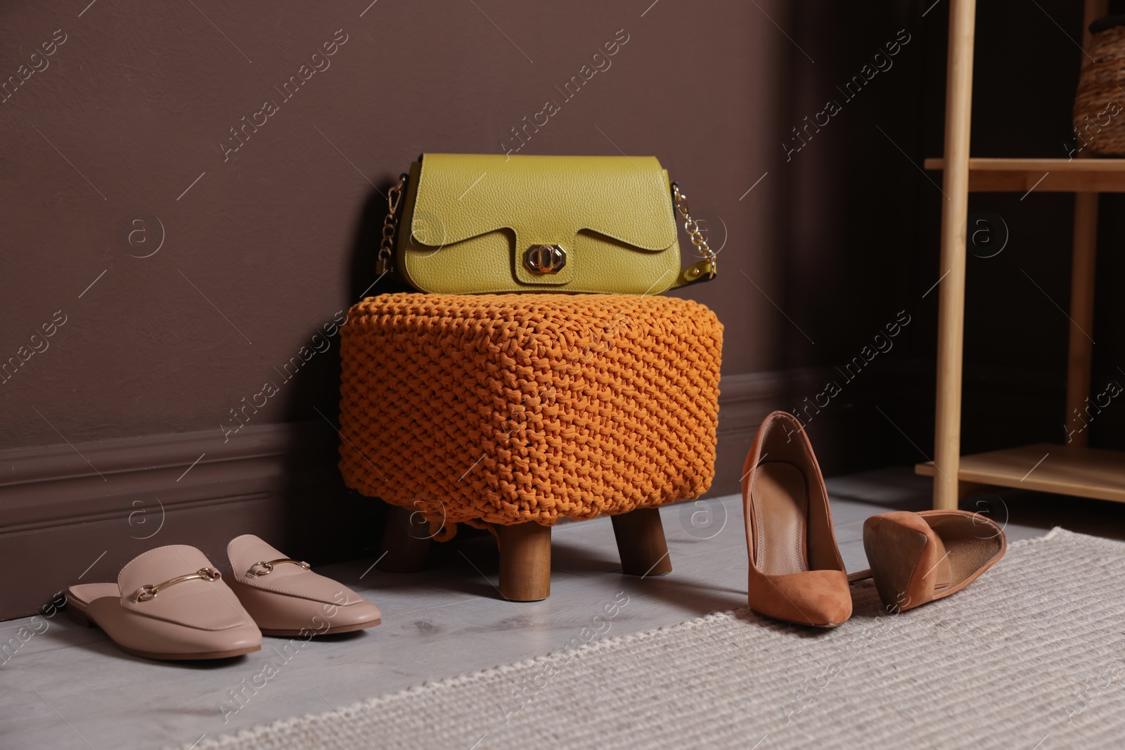 Stylish pouf with bag and shoes at home Photo of Stylish pouf with bag and shoes at home
