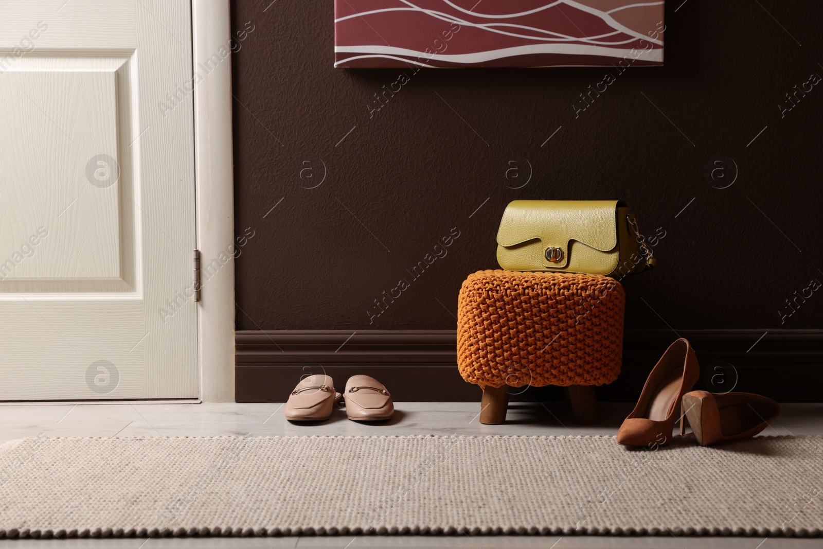 Photo of Stylish pouf with bag and shoes at home