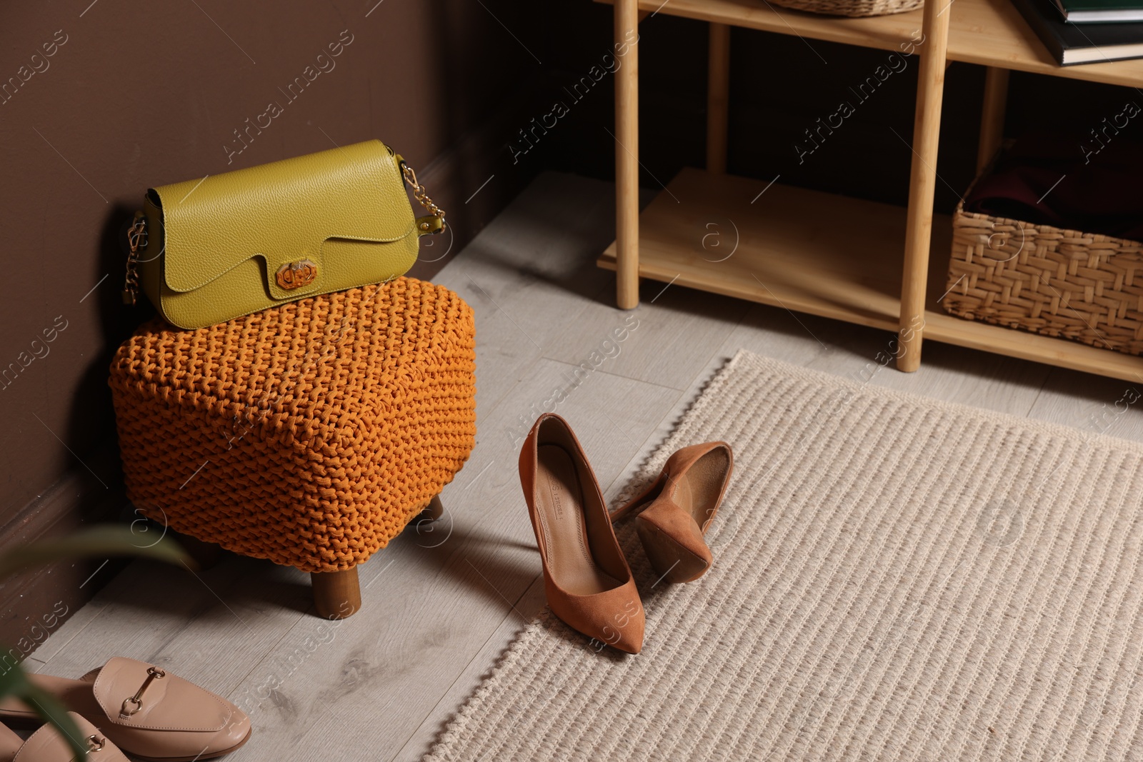 Stylish pouf with bag and shoes at home Photo of Stylish pouf with bag and shoes at home