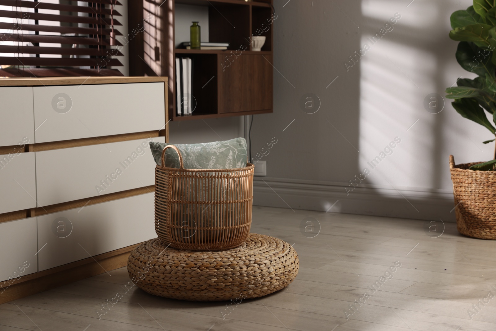 Stylish wicker pouf and home decor indoors. Space for text Photo of Stylish wicker pouf and home decor indoors. Space for text