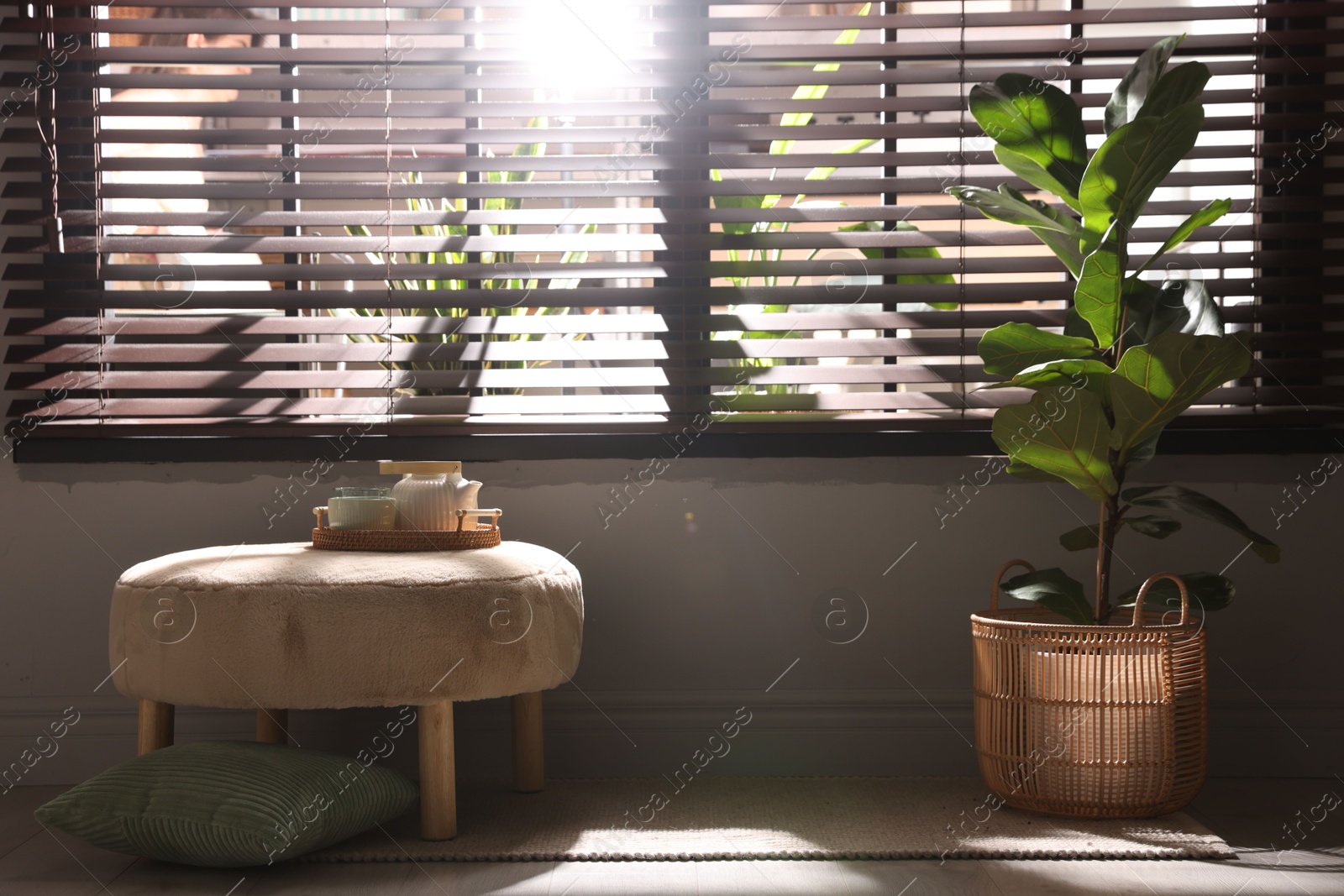 Stylish pouf with tea set in living room Photo of Stylish pouf with tea set in living room