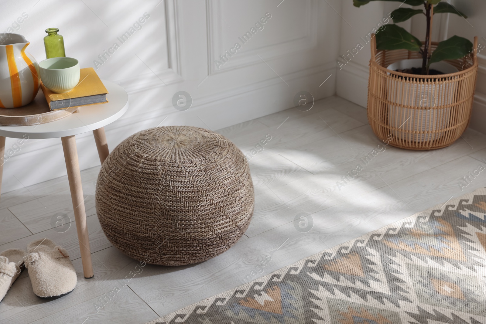 Stylish knitted pouf and home decor indoors Photo of Stylish knitted pouf and home decor indoors