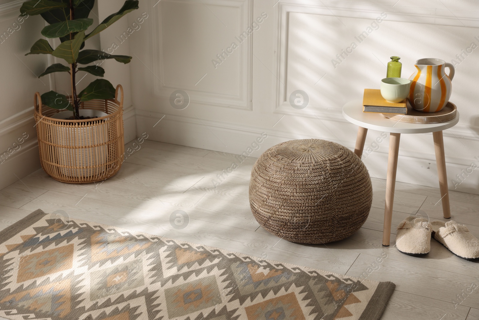 Stylish knitted pouf and home decor indoors Photo of Stylish knitted pouf and home decor indoors