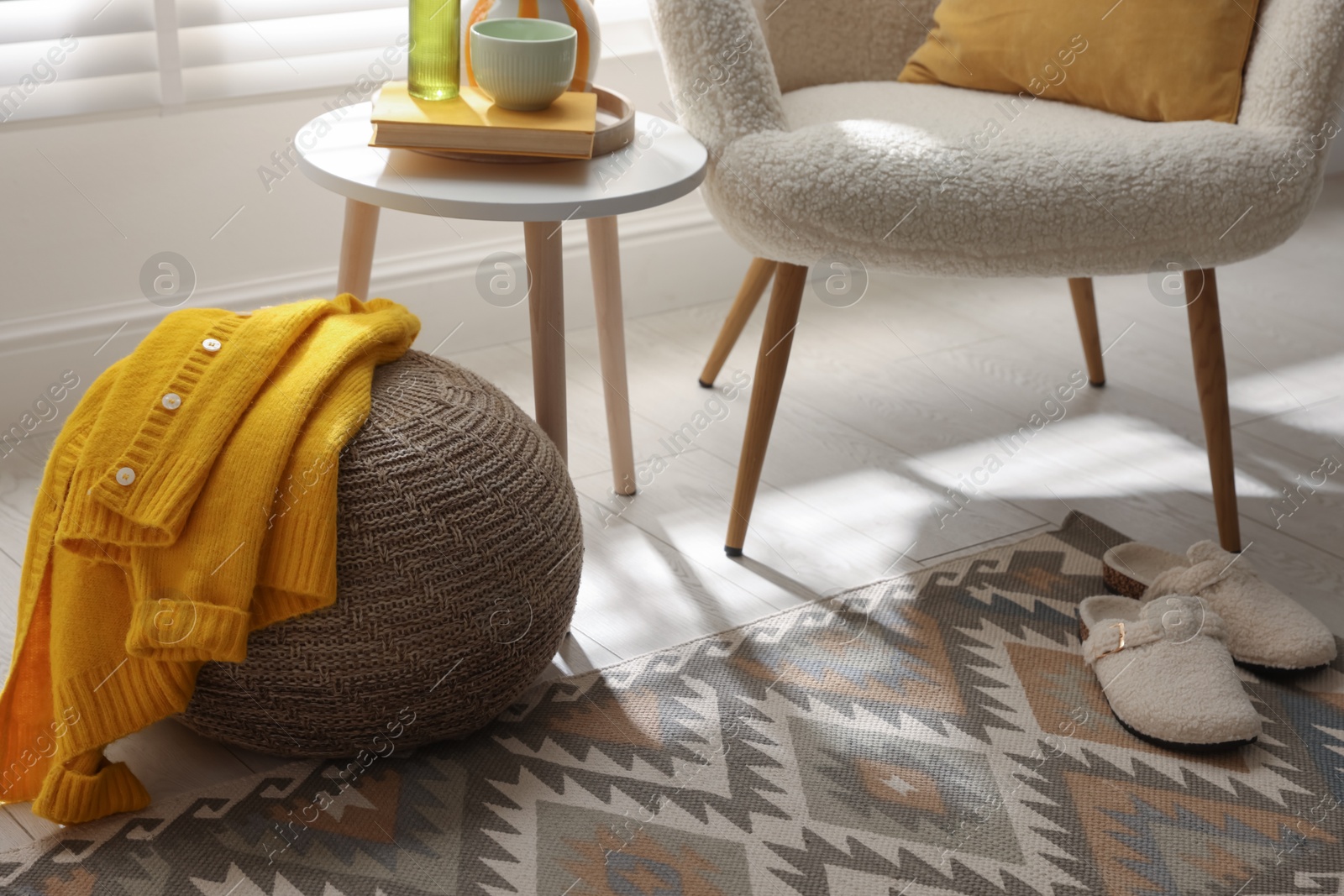 Stylish knitted pouf with sweater at home Photo of Stylish knitted pouf with sweater at home