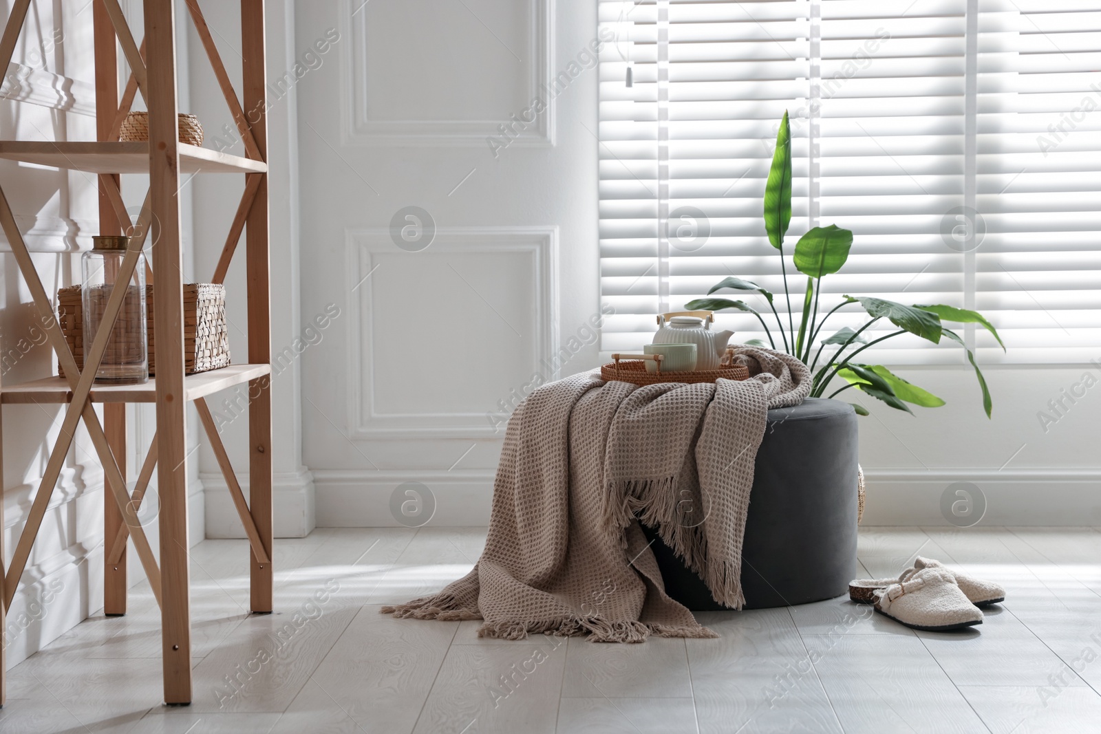 Stylish pouf with tea set at home Photo of Stylish pouf with tea set at home