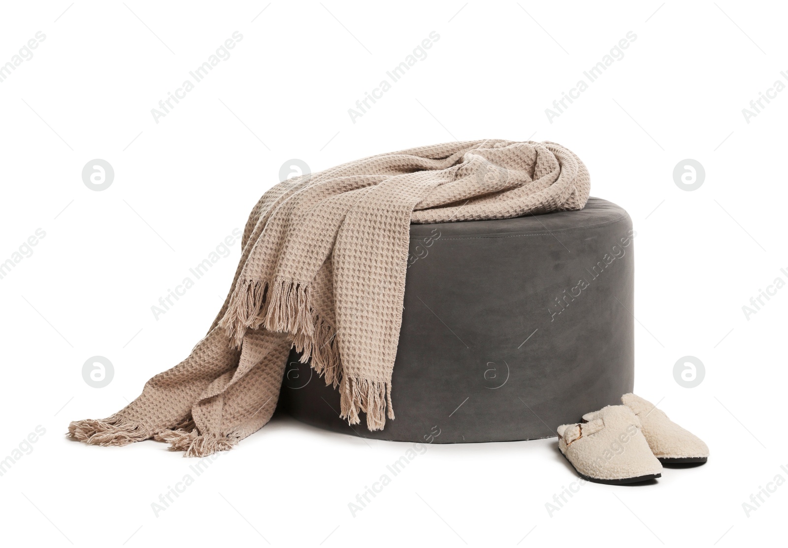 Stylish pouf with plaid and slippers isolated on white Photo of Stylish pouf with plaid and slippers isolated on white