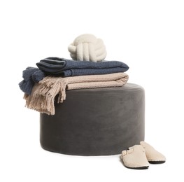 Photo of Stylish pouf with plaids, cushion and slippers isolated on white