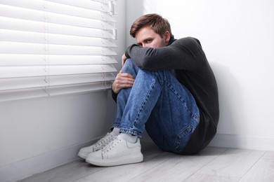 Photo of Man suffering from paranoia near window at home