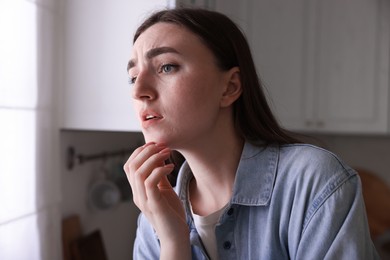 Photo of Worried woman suffering from paranoia in kitchen