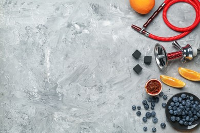 Photo of Hookah, coal and fresh fruits on grey table, flat lay. Space for text