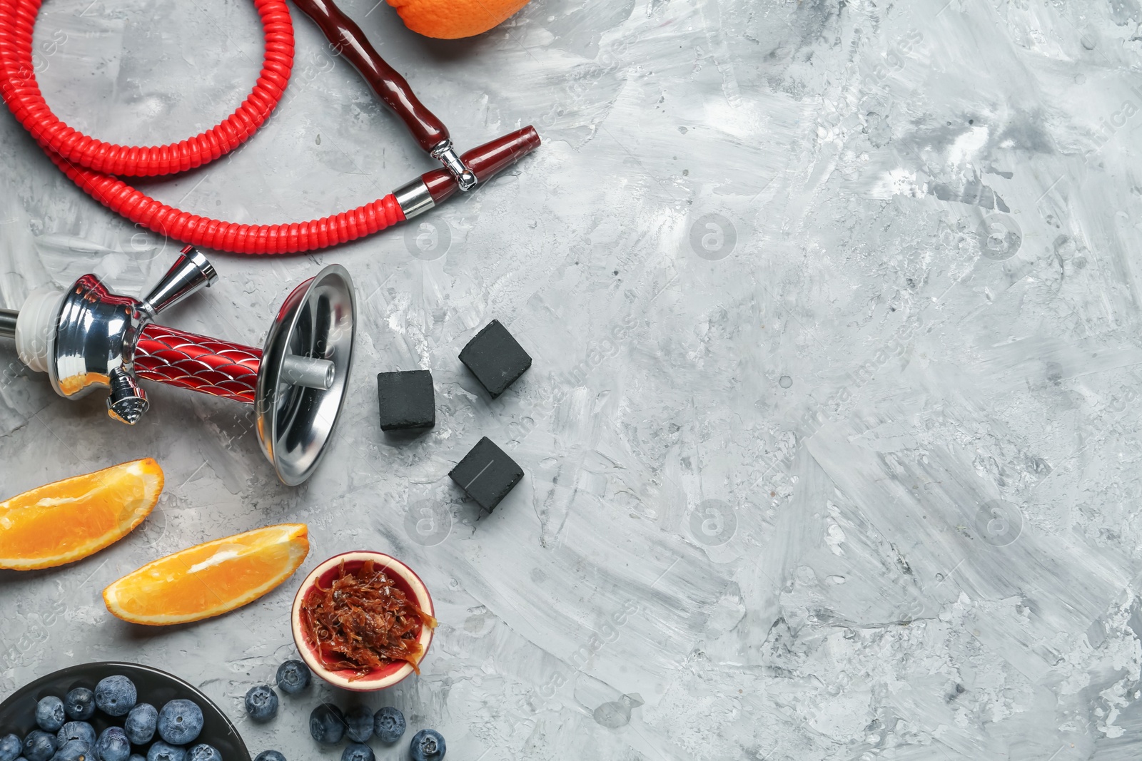 Photo of Hookah, coal and fresh fruits on grey table, flat lay. Space for text