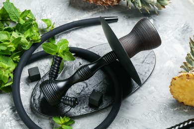 Photo of Hookah, coal and fresh fruits on grey table, closeup