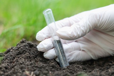 Photo of Scientist taking soil sample for research outdoors, closeup