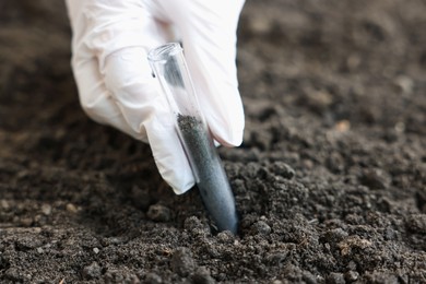 Photo of Scientist taking soil sample for research outdoors, closeup