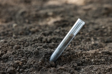 Photo of Test tube with soil sample outdoors, closeup. Space for text