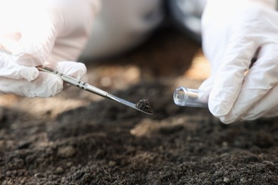 Photo of Scientist taking soil sample for research outdoors, closeup