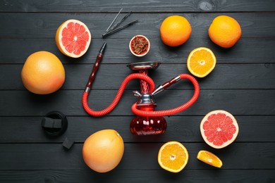 Photo of Hookah, coal and fresh fruits on black wooden table, flat lay