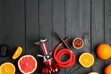 Photo of Hookah and fresh fruits on black wooden table, flat lay. Space for text