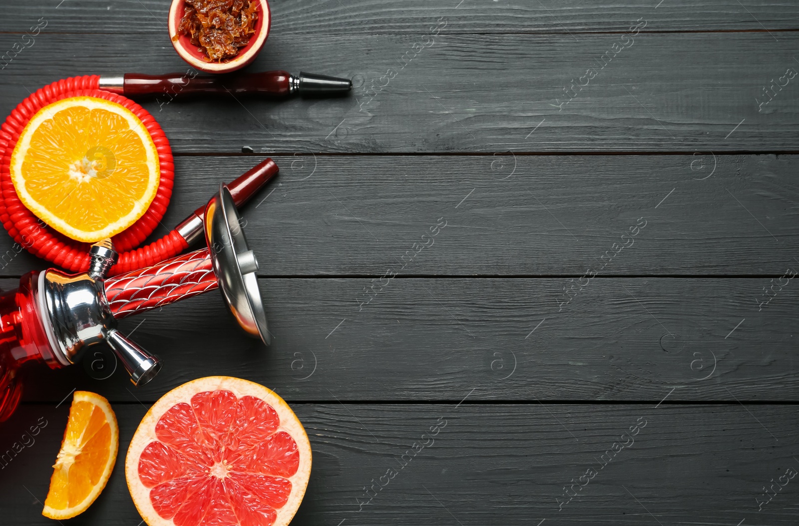 Photo of Hookah and fresh fruits on black wooden table, flat lay. Space for text