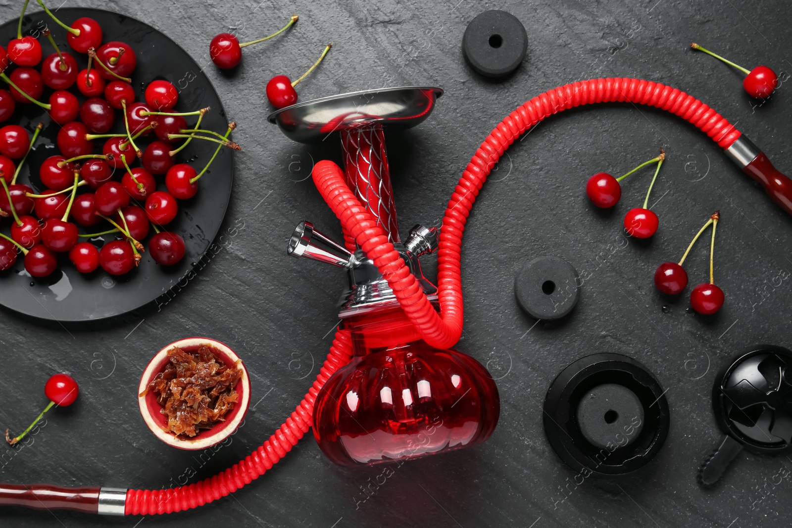Photo of Hookah and cherries on black table, flat lay