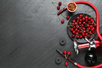 Photo of Hookah and cherries on black table, flat lay. Space for text