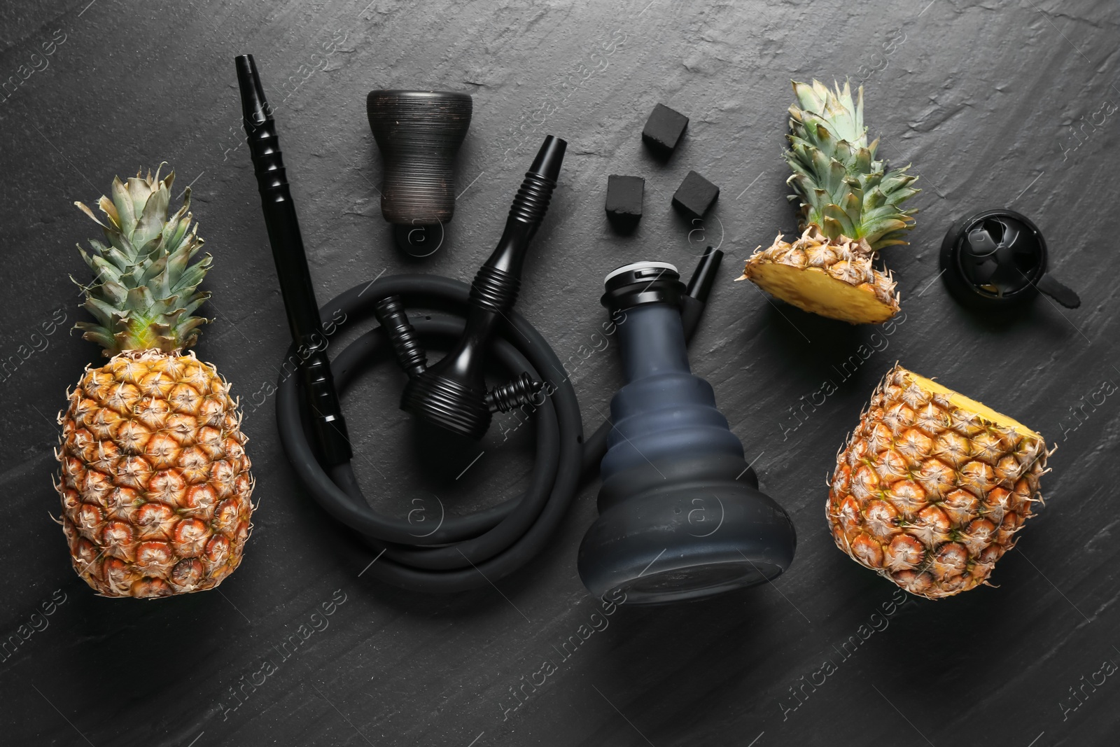 Hookah, coal and pineapples on black table, flat lay Photo of Hookah, coal and pineapples on black table, flat lay