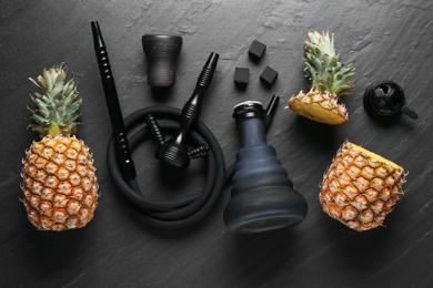 Photo of Hookah, coal and pineapples on black table, flat lay