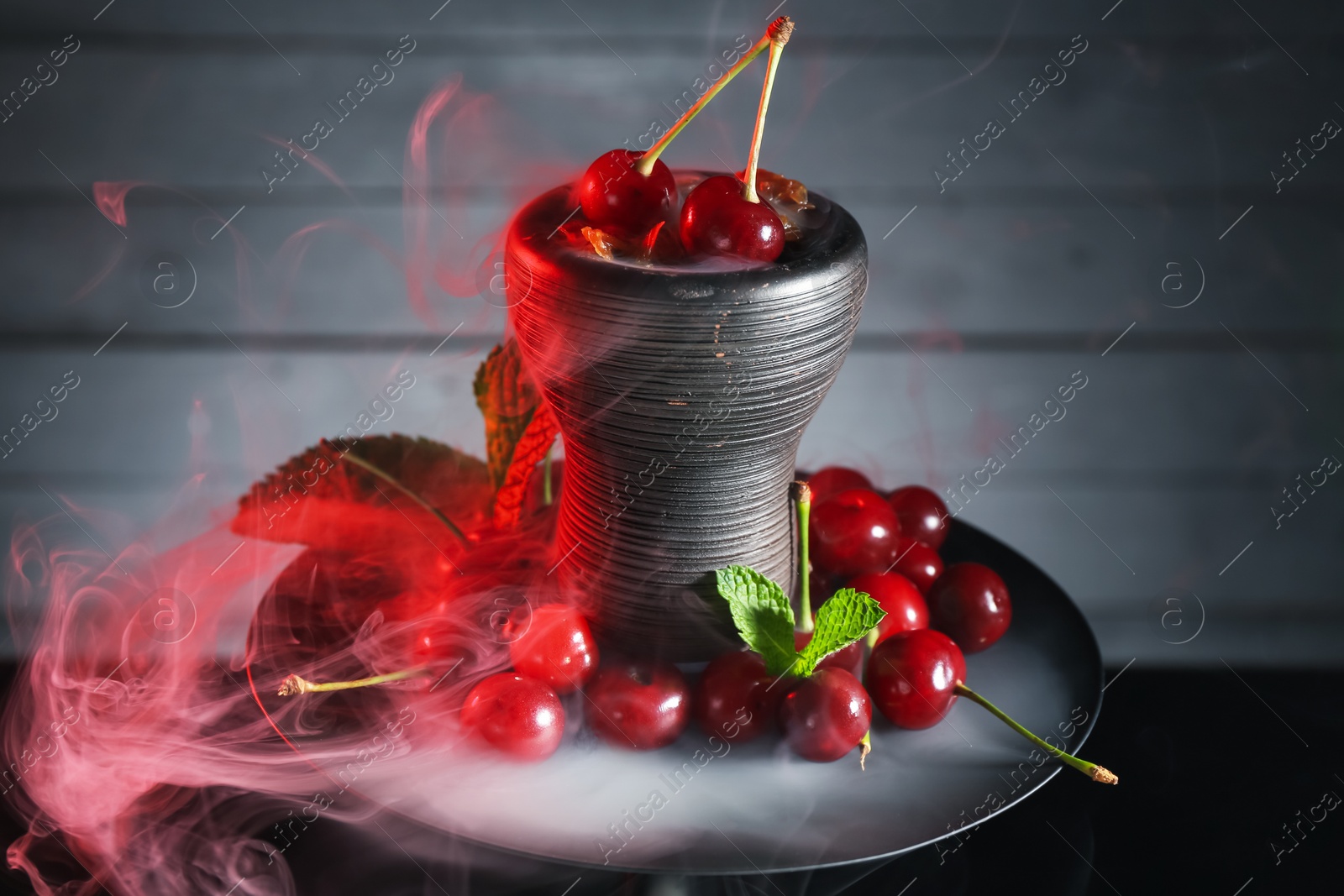 Photo of Hookah with cherries and smoke on black background, closeup