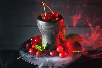 Photo of Hookah with cherries and smoke on black background, closeup