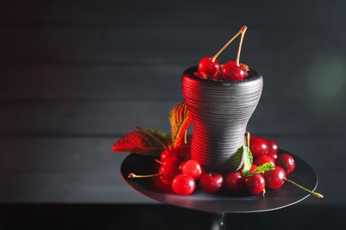 Photo of Hookah with cherries and smoke on black background, closeup. Space for text