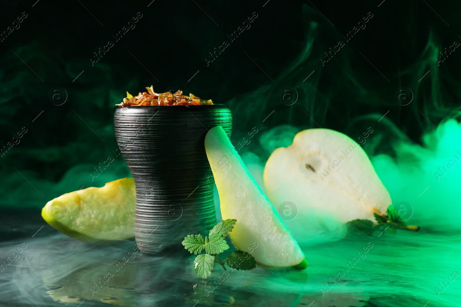 Hookah bowl with pear pieces, mint and smoke on black table, closeup Photo of Hookah bowl with pear pieces, mint and smoke on black table, closeup