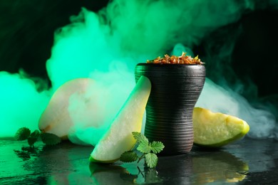 Photo of Hookah bowl with pear pieces, mint and smoke on black table, closeup