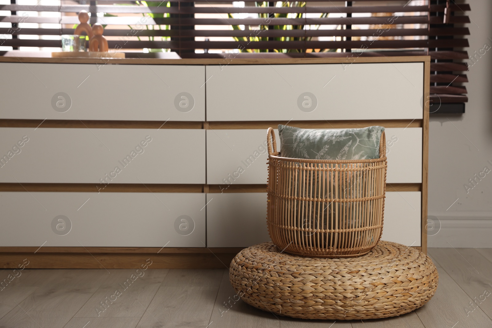 Stylish wicker pouf and home decor indoors Photo of Stylish wicker pouf and home decor indoors
