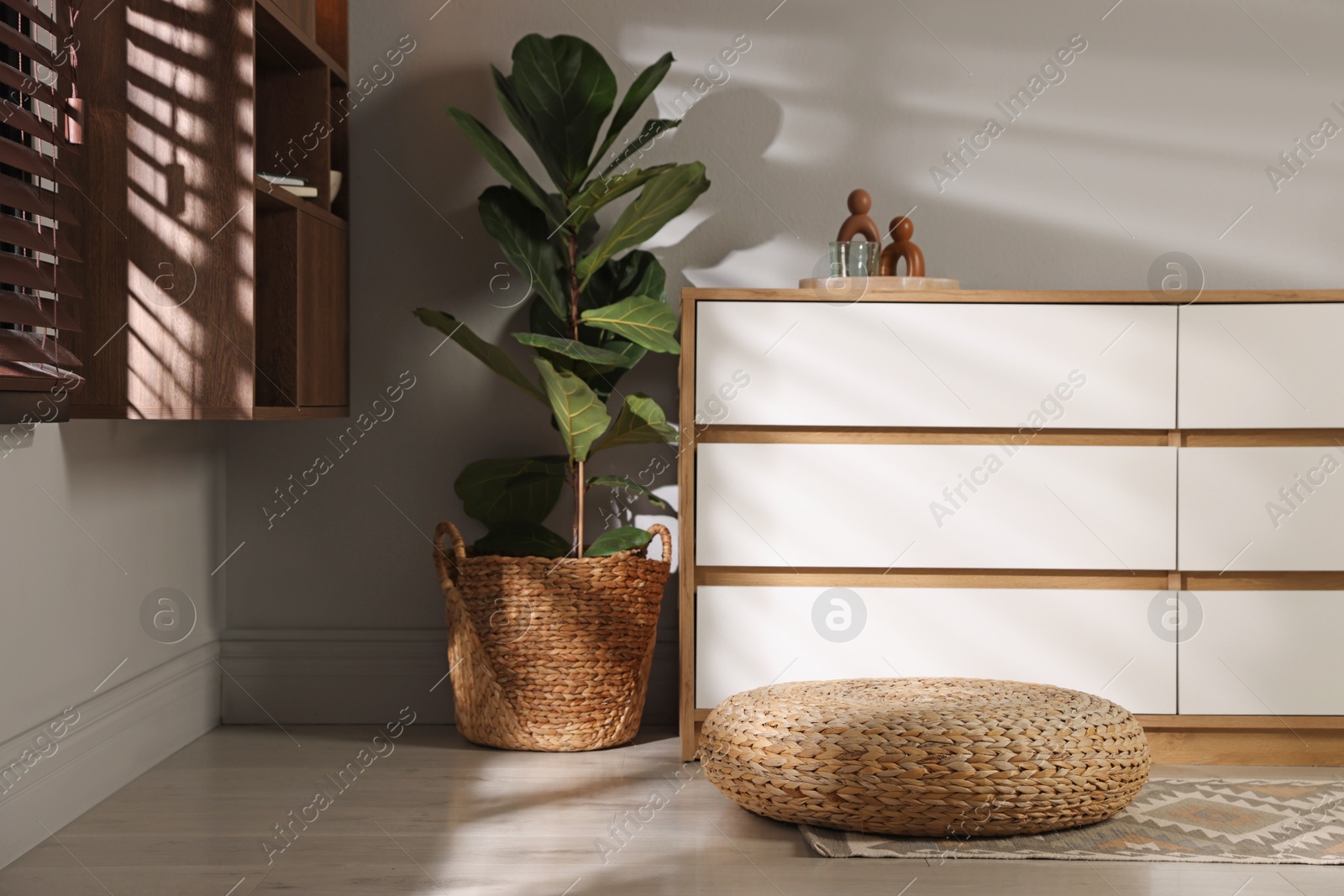Stylish wicker pouf and home decor indoors Photo of Stylish wicker pouf and home decor indoors